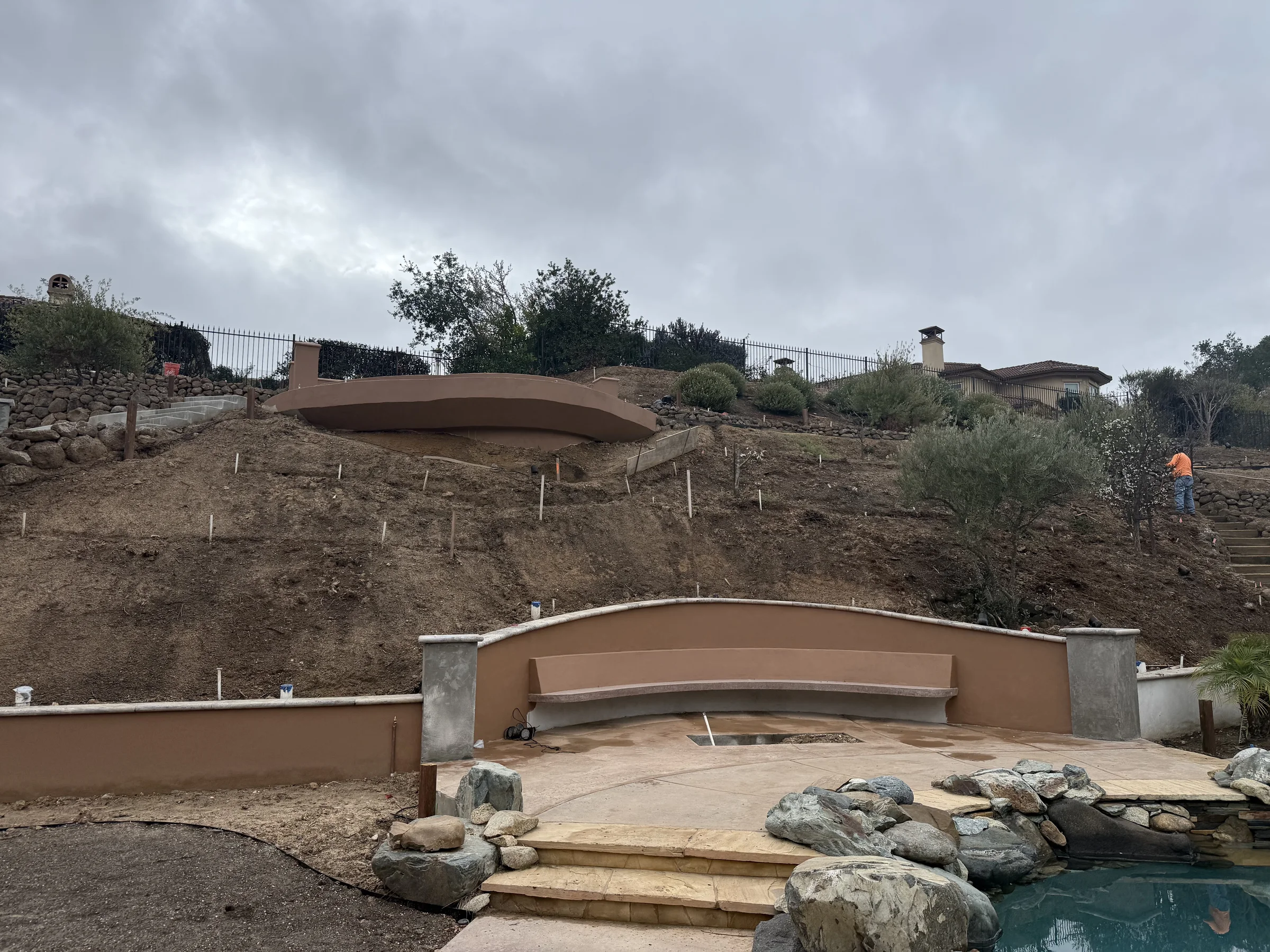 The original exposed hillside rising behind the existing lower terrace.