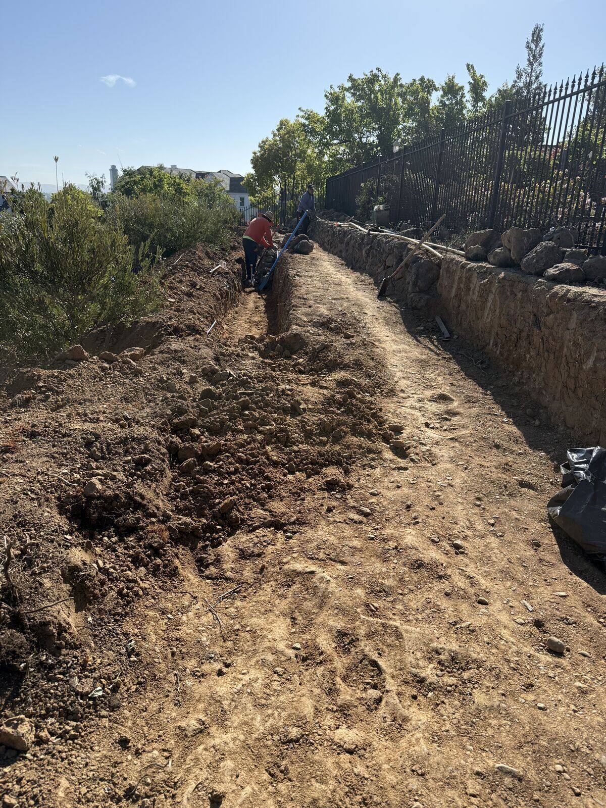 A deep excavation cut tracing the future route up the hillside.