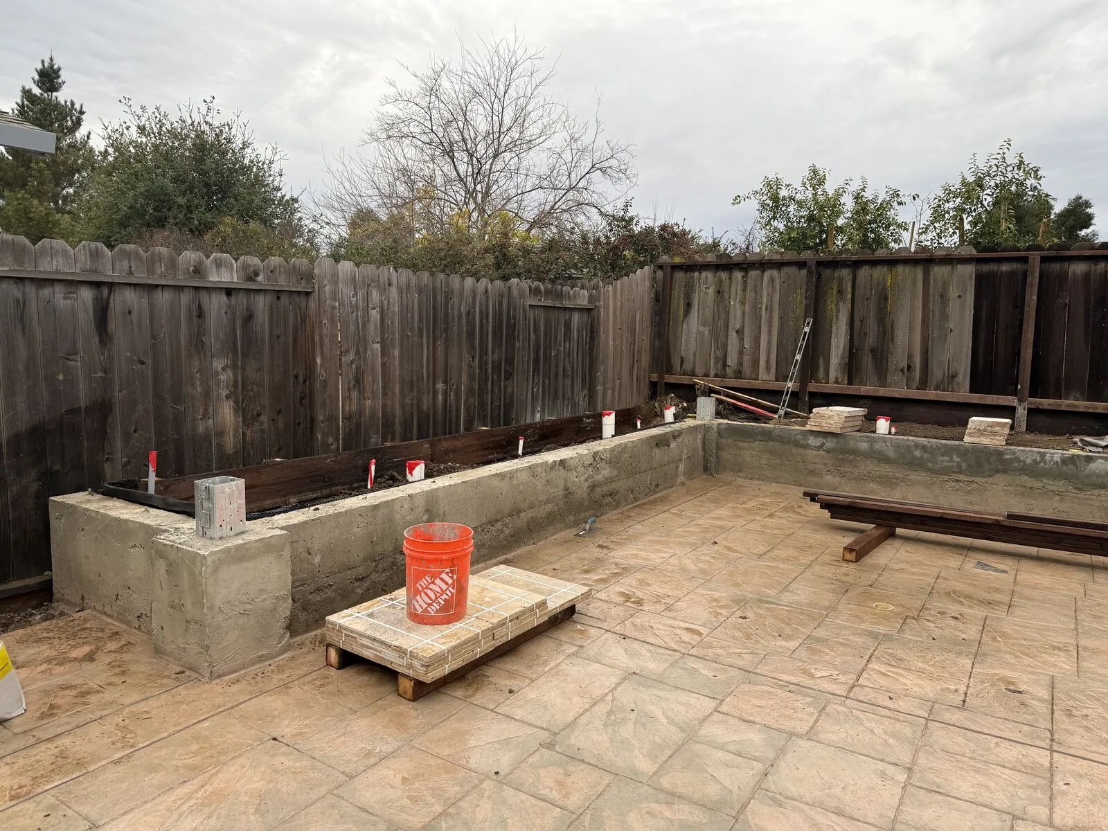 New concrete retaining walls defining the long edge of the Hernandez backyard.