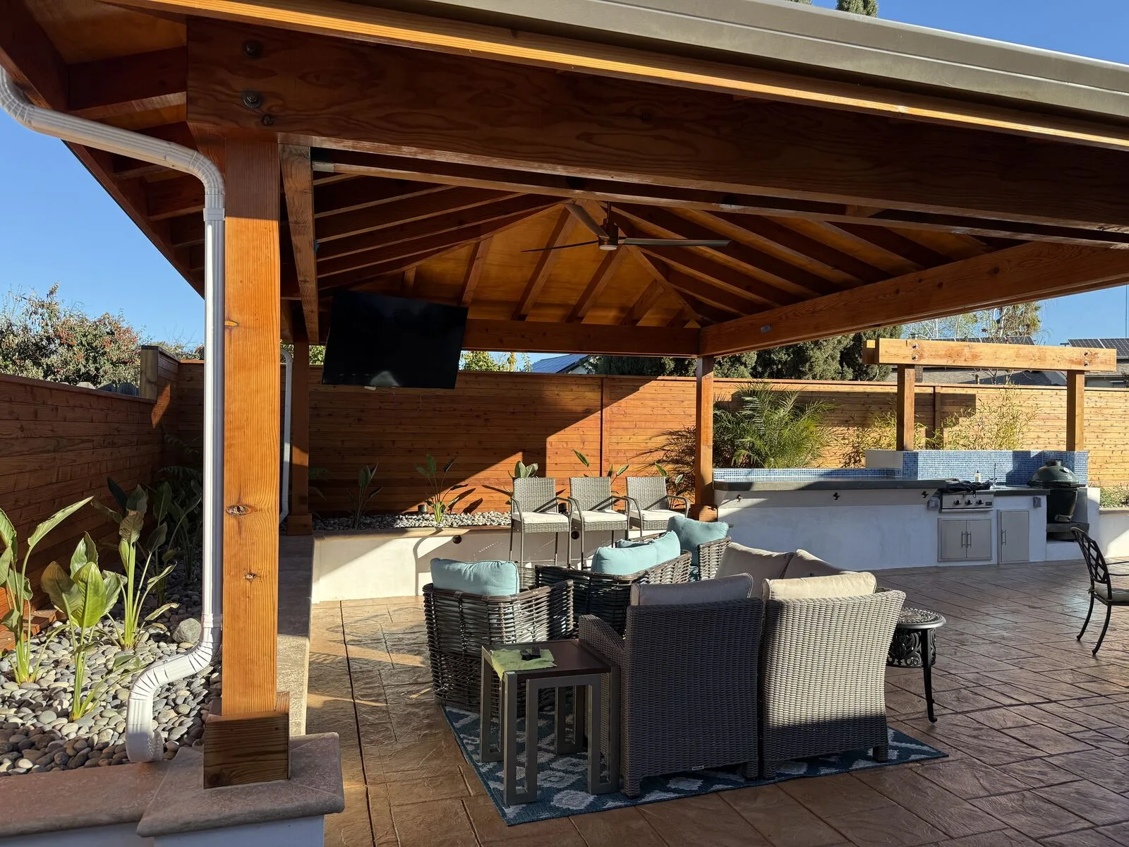 The completed covered outdoor kitchen and dining room furnished for a family gathering.